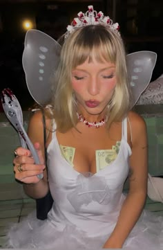 a woman in a fairy costume holding scissors