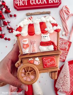 a hand is holding up a hot cocoa bar ornament