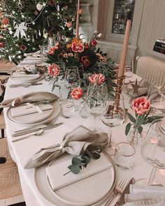 a table set with place settings and flowers