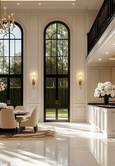 an elegant dining room with chandelier and large windows, white walls and marble flooring