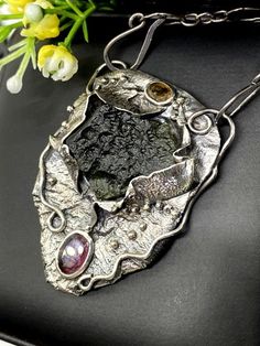 ARTISAN MOLDAVITE and TOURMALINE PENDANT  Hand-made Sterling Silver 925.  Stones used: Moldavite, Pink&Green Tourmaline  Height -2 1/8” (with bail), Width – 1 1/2”  Height – 53mm, width-38mm.Unique Handcrafted One-of a-kind Design PendantEach Piece of Jewelry in my Collection is Absolutely One of a Kind!When you start wearing a piece of my jewelry you will fall in love with it more and more each day and feel that good Energy and Love that I pass into it while creating this piece of Art.A pie Moldavite Pendant, Meteorite Pendant, Turquoise Statement Ring, Amber Gemstone, Asymmetrical Earrings, Tourmaline Pendant, Set Jewelry, Royston Turquoise, Unique Gemstones