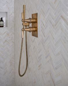 an old fashioned shower faucet in a bathroom with herringbone tiles on the wall