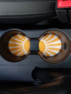 two yellow and white balls in the center console of a car