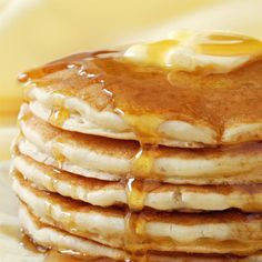 a stack of pancakes covered in syrup and butter