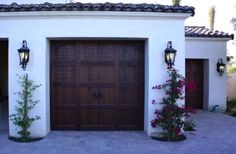 a house with two garage doors and some flowers