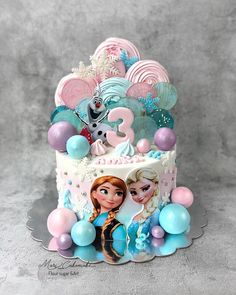 a frozen princess birthday cake with balloons and decorations on the bottom tier, including an edible topper