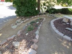 a bench sitting in the middle of a park area with rocks and gravel around it