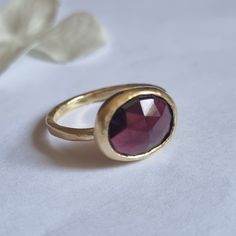 "Beautiful solitaire garnet ring, boho oval gemstone jewelry for women, available in 14k gold plating, sterling silver, 9k yellow gold, or 14k yellow gold.  This statement handmade gold ring is set with a natural oval faceted garnet. It is available in high-quality 14k gold plating, sterling silver, 9k yellow gold, or 14k yellow gold.  Garnet is January's birthstone, making this ring a great gift option for yourself or a loved one with a January birthday. The gem's color blends seamlessly with t Handmade Oval Yellow Gold Stackable Rings, Handmade 14k Gold Oval Rings, Oval Ruby Gemstone Stackable Rings, Oval Garnet Rings, Gold Faceted Ruby Ring, Handmade Gold Topaz Ring With Oval Shape, Handmade Gold Topaz Ring In Oval Shape, Oval Garnet Ring In Yellow Gold, Garnet Gemstone Signet Ring