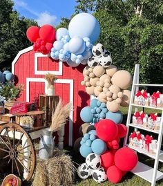 a red barn decorated with balloons, hay and farm animals for an outdoor birthday party