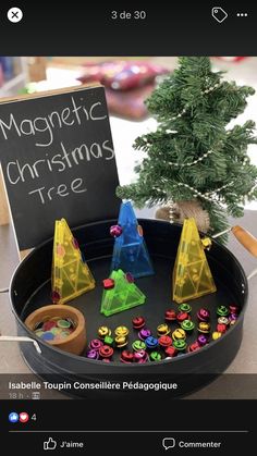 a christmas tree made out of plastic cones and magnets on a table with a sign that says magnetic christmas tree