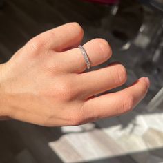 a person's hand with a diamond ring on it