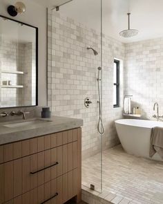 a bath room with a tub a sink and a mirror on the wall in it