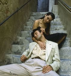 a man and woman sitting on some stairs