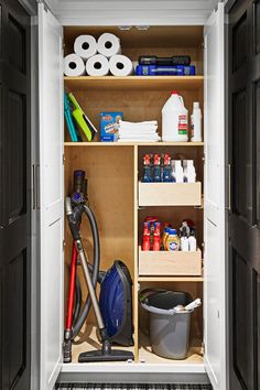 an open closet with various items and cleaning supplies in the cupboards, including a vacuum cleaner