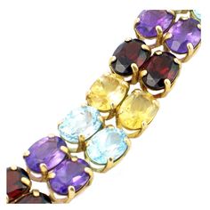 "Love to dazzle with gemstones? Here is one impressive bracelet that flaunts blue topaz, citrine, garnet and amethyst all at once! Crafted with a double row of alternating 7 x 5 mm gems on a sturdy structure of 10K gold. Box style clasp with safety loop. Vintage: Late 1980s - Mid 1990s Materials: 10K Gold with 12 Citrine, 12 Garnet, 10 Blue Topaz, 8 Amethyst Length: 6 3/4\" Width @ Widest Point: 3/8\" 42 Oval Gemstones: approx. 7 x 5 mm each Weight: 9.6 dwt / 14.9 g Condition: Excellent FREE PRI Luxury Multicolor Amethyst Gemstones, Luxury Multicolor Amethyst Jewelry, Formal Multicolor Amethyst Jewelry, Formal Multicolor Natural Gemstones, Multi-stone Amethyst Bracelet, 10k Gold Bracelet, Colorful Gemstones, Gold Box, Saint Louis