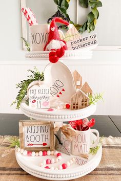 three tiered trays with christmas decorations on them and two signs that say kissing booth