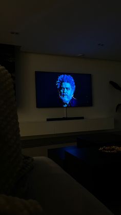 a person sitting in front of a flat screen tv with the image of bob white on it