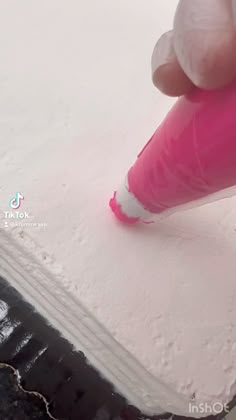 someone is using a pink marker to paint the surface of a piece of white paper