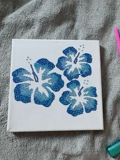 a painting with blue flowers on it next to two markers and a pencil in the background