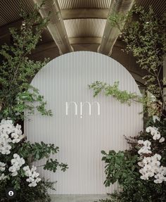 the entrance to an outdoor wedding venue with white flowers and greenery