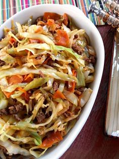 a white bowl filled with cabbage and meat