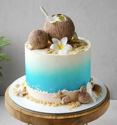 a blue and white ombretta cake with coconuts on top, sitting on a table