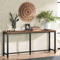 a wooden table topped with two vases next to a metal deer head on a wall