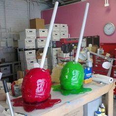 two red and green objects sitting on top of a workbench in a garage