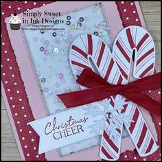 a close up of a christmas card with candy canes on it and a ribbon