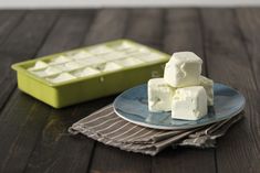 a plate with marshmallows on it next to a green container