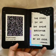 someone is holding up an open book with some writing on the pages and stars in my sky shine brighter with you, by my side