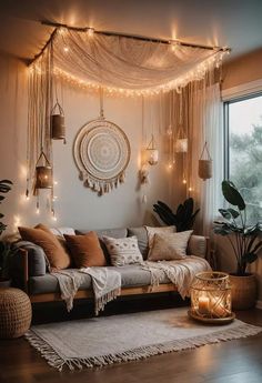 a living room filled with lots of furniture and lights hanging from the ceiling above it