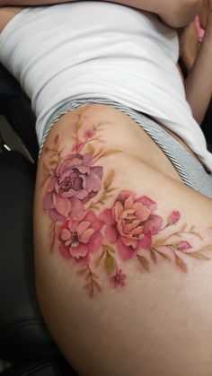 a woman laying down with her stomach covered by flowers on the side of her body