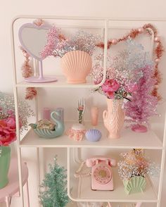 a shelf filled with vases and other items on top of white shelve