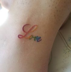 the word love is written in multicolored letters on the left side of the arm