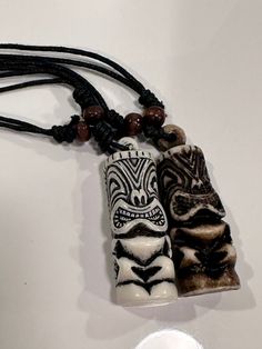 two white and black beaded necklaces hanging from a cord