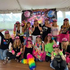 a group of women in pink and green hats pose for a photo on the stage