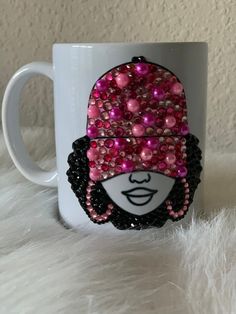 a coffee mug with pink and black sequins on it, featuring a woman's face