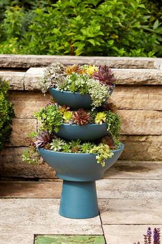 three tiered planters filled with plants on a patio