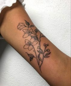 a woman's arm with a flower tattoo on it