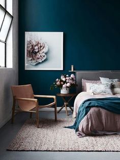 a bed room with a neatly made bed and blue walls