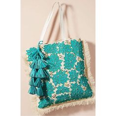 a blue and white bag with tassels hanging from it's side on a wall