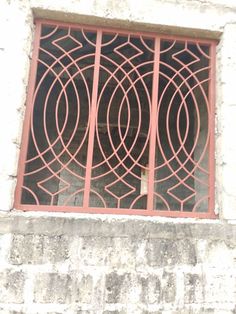 a cat sitting in the window sill of an old building with iron bars on it