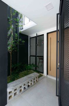 an entry way with a bench and plants in the center, surrounded by black doors