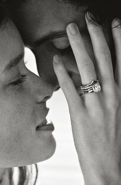 a man and woman kissing each other with rings on their fingers