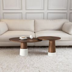 two white couches sitting next to each other on top of a carpeted floor