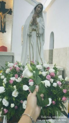 a person placing flowers in front of a statue