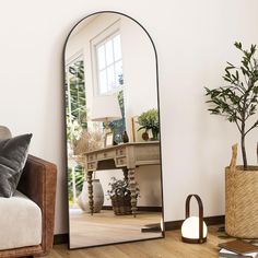 a large mirror sitting on top of a wooden floor next to a couch and table