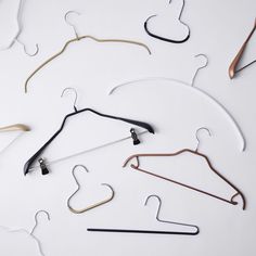 several pairs of clothes hangers on a white surface