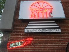 the neon sign on the building says, sports atti and restaurant tavern music venue